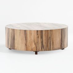 a round wooden table sitting on top of a white floor