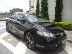 a small black car parked on the side of the road