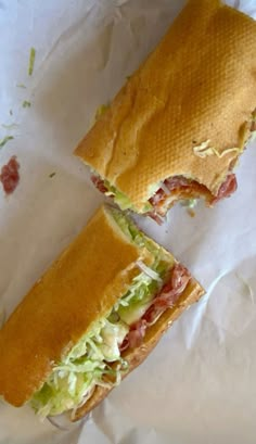 the sandwich is cut in half and ready to be eaten on the paper wrapper