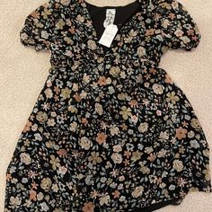 These Colors Could Go Either Way! Dress This Up With Black Leggings And Boots, Or Wait Till The First Day Of Spring With The Muted Spring Pastels! This Dress Is Adorable! While It Is A Large It Runs On The Smaller Side! Black Floral Dress With Short Sleeves For Spring, Black Ditsy Floral Print Dress For Summer, Black Ditsy Floral Dress For Summer, Black Puff Sleeve Dress With Floral Print, Black Summer Dress With Ditsy Floral Print, Black Ditsy Floral Print Dress For Vacation, Chic Black Dresses With Ditsy Floral Print, Black Floral Short Sleeve Dress For Day Out, Black Floral Short Sleeve Dress For Beach