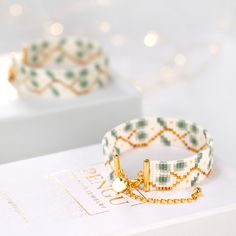 two bracelets sitting on top of a white box