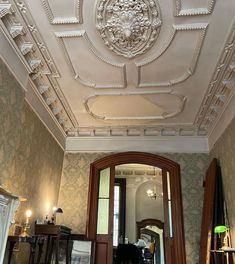 an ornately decorated room with wooden floors and white ceilinging, along with antique furniture