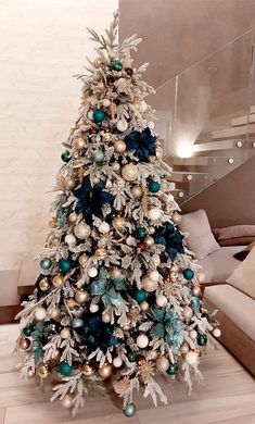 a white christmas tree with blue and gold ornaments