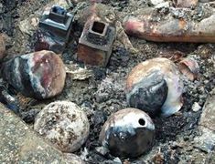 several pieces of metal sitting on top of some dirt and rocks with rusted paint