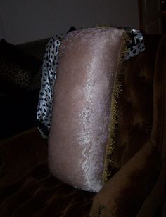 a leopard print pillow sitting on top of a brown couch