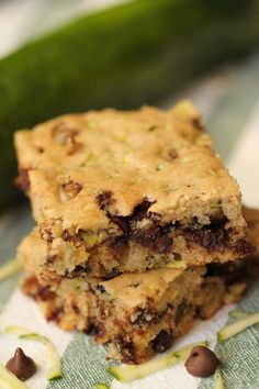 two chocolate chip bars stacked on top of each other next to a cucumber