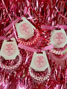 pink and white items are displayed on red tinsels with ribbons in the background