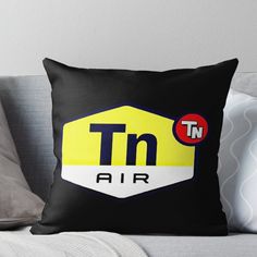 a black and yellow throw pillow with the word tn air on it's side