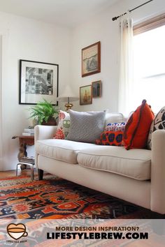 a living room with white couches and colorful pillows on top of the rugs