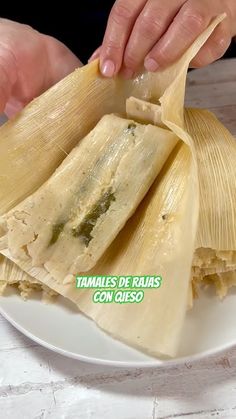 a person is holding some tamales on a plate