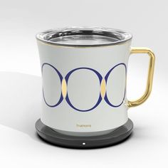 a white and gold coffee mug with three circles on it