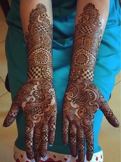 two hands with henna tattoos on them