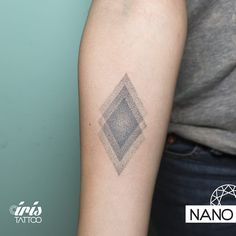 a woman's arm with a diamond tattoo on the left side of her arm