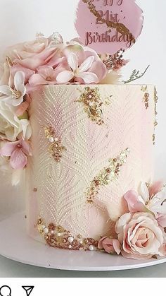 a pink and gold birthday cake decorated with flowers