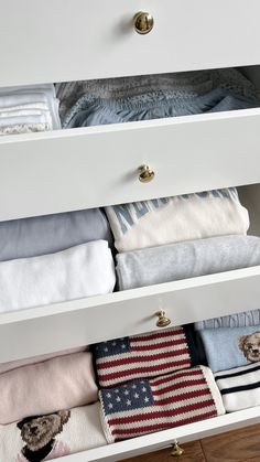 an organized drawer with folded towels and blankets