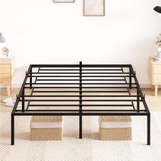 a black metal bed frame in a room with two nightstands and pictures on the wall