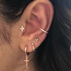 a woman wearing three different types of ear piercings on her left side of the ear