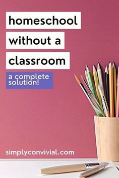 a wooden cup filled with pencils on top of a white table next to a pink wall