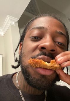 a man with dreadlocks is taking a bite out of chicken nuggies