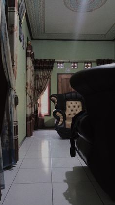 an empty room with chairs and curtains on the windowsills, in front of a doorway