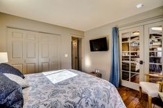 a bedroom with a large bed and wooden floors