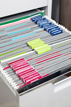 a drawer with several file folders in it and some papers on the bottom shelf