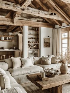 a living room filled with furniture and wooden beams