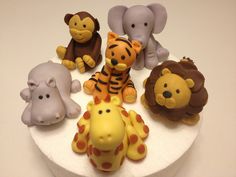 there are many different toy animals on the cake