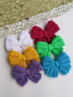 four crocheted bows are sitting on a table