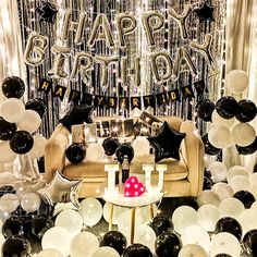 a birthday party with black and white balloons, silver foil streamers and balloon decorations