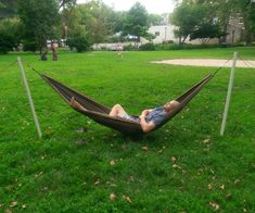 a man laying in a hammock on the grass