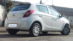 a small white car parked in front of a building