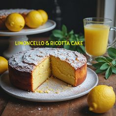 there is a cake on the table with lemons next to it and a glass of orange juice