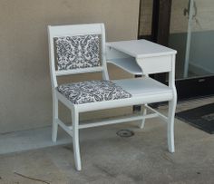 a white desk and chair sitting on the side of a building next to a door