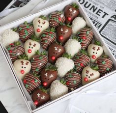 a box filled with chocolate covered strawberries on top of a table