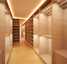 an empty walk - in closet with wooden shelves and lights on the ceiling is lit by recessed lighting