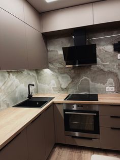 a kitchen with wooden counter tops and gray cabinets, along with a black stove top oven