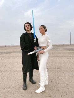 two people dressed up as characters from star wars standing next to each other in the desert