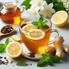 a cup of tea with lemon slices and mint on the side, surrounded by other ingredients