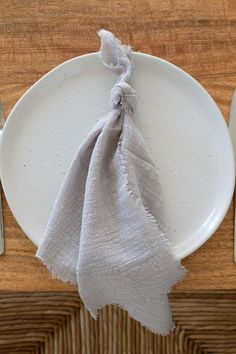 a white plate with a napkin on top of it next to silver utensils