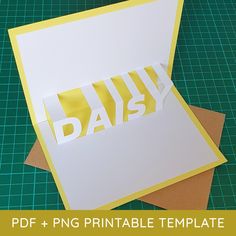 a card with the word daisy cut out on top of it, next to a pair of scissors