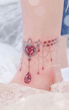 a close up of a person's foot with a heart and chain tattoo on it