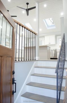 a staircase leading to a kitchen with a ceiling fan