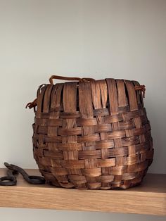 a woven basket sitting on top of a wooden shelf next to a pair of scissors