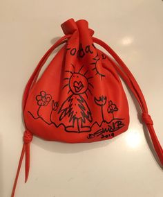 an orange drawstring bag with drawings on it