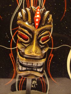 a mask is on display in front of a black background with red and orange lines