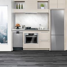 a modern kitchen with stainless steel appliances and white cabinets, overlooking the cityscape