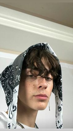 a young man wearing a bandana over his head