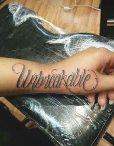 a person with a tattoo on their arm that reads, unforkedible in cursive writing