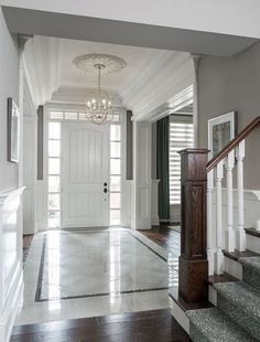 an entry way with stairs, chandelier and pictures on the wall